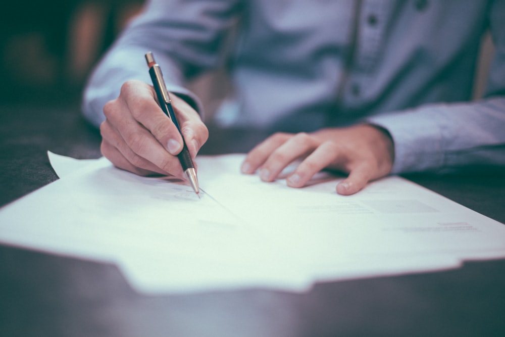A hand signing a legal contract