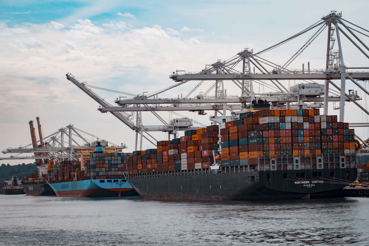 Container ship and port cranes handling cross-border cargo
