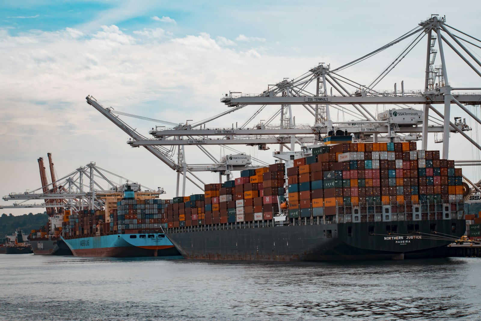 Container ship and port cranes handling cross-border cargo